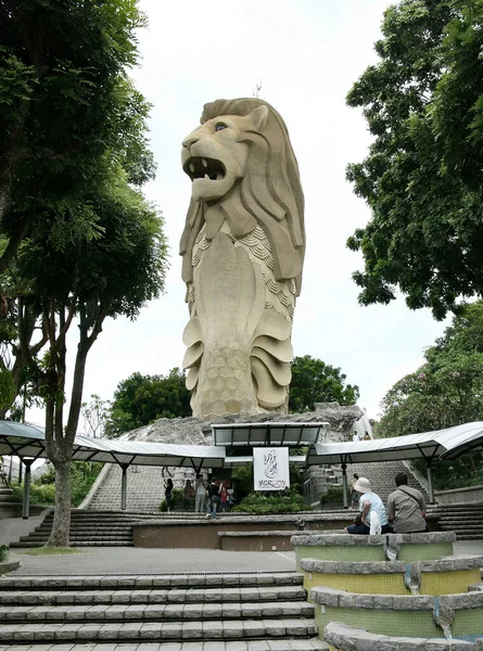 2007年7月5日 新加坡Sentosa岛海拔3700米的Merlion Statue塔在一个旅游中心上方 可以看到一小群游客摆姿势拍照 另外两名游客在右边休息 — 图库照片