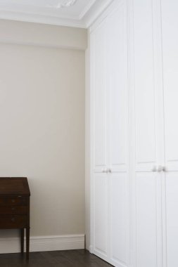 Kahverengi zemin kolları ve kahverengi çekmeceli beyaz dolap kapıları.