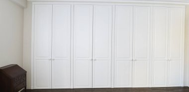 Kahverengi zemin kolları ve kahverengi çekmeceli beyaz dolap kapıları.