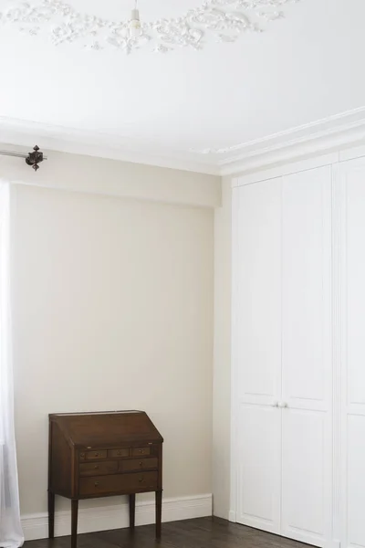 Kahverengi zemin kolları ve kahverengi çekmeceli beyaz dolap kapıları.