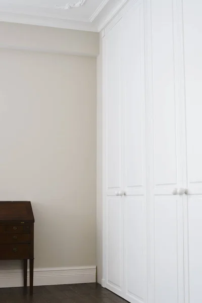 Kahverengi zemin kolları ve kahverengi çekmeceli beyaz dolap kapıları.