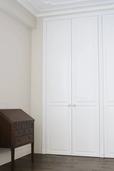 Kahverengi zemin kolları ve kahverengi çekmeceli beyaz dolap kapıları.