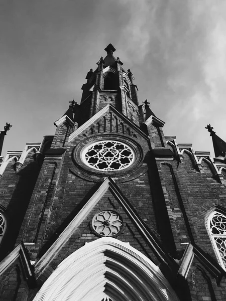 Siyah beyaz gökyüzüne bakan bir kilise binasının köşeleri..