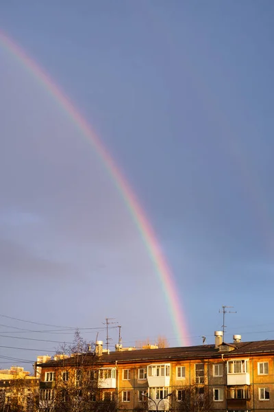 Evlerin üzerinden geçen yağmurdan sonra çok renkli gökkuşağı
