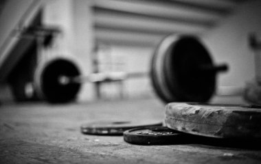 Diskler ve ağırlık kaldırma halterleri dramatik bir ışık ile kesişen bir spor salonunda