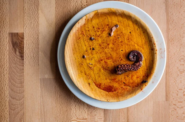 Pulpo a la gallega 'nın yakın plan fotoğrafı, ahtapot haşlanmış, tipik İspanyol Galiçya yemeği, geleneksel ahşap bir tabakta, kopyalama alanı ile birlikte.