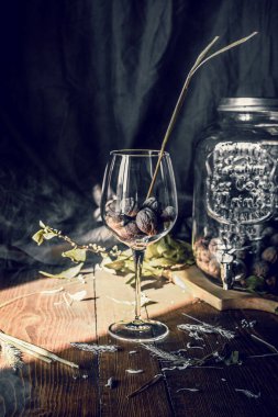 Siyah arka planı olan tahta bir masada bir bardak fındık.