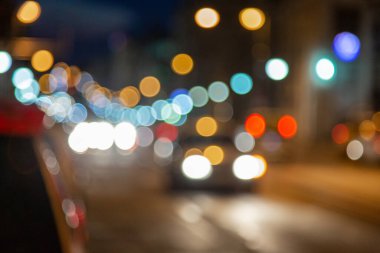 Araba gece Bokeh 'te bir şehir yolunda gidiyor. Akşam trafiği