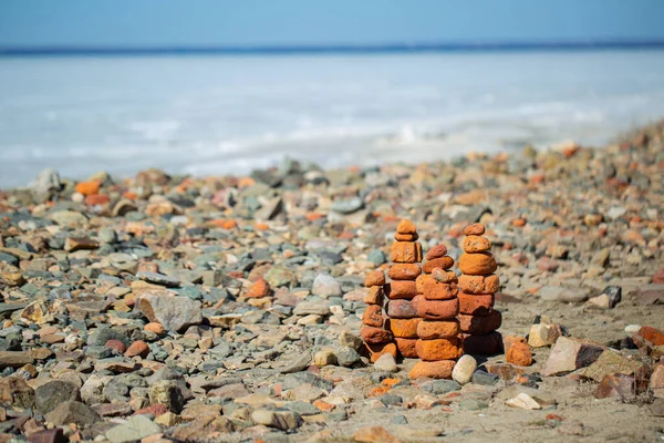 Orange stone pyramids on a sea stone beach.