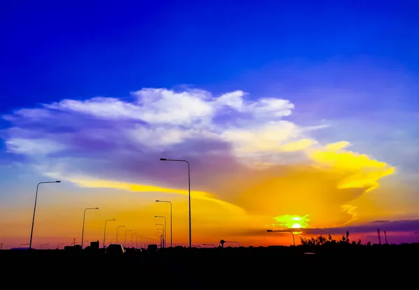 Zonsondergang landschap met prachtige cloud langs de weg — Stockfoto