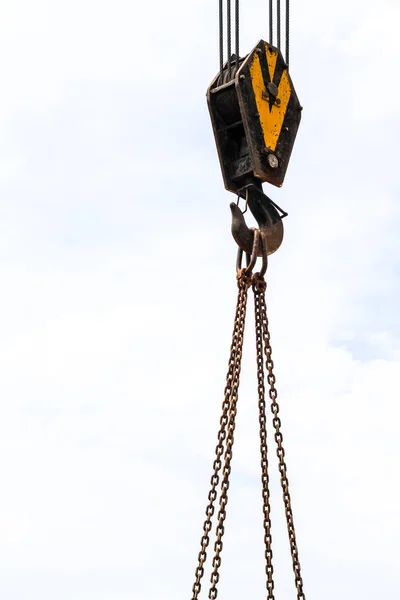 Haak van de kraan en de ketting op de blauwe hemelachtergrond — Stockfoto