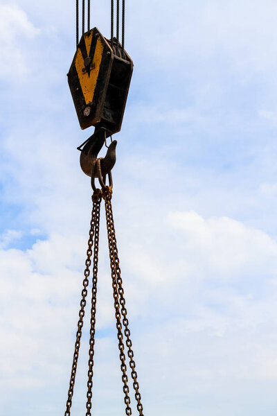 Crane hook and chain on the blue sky background