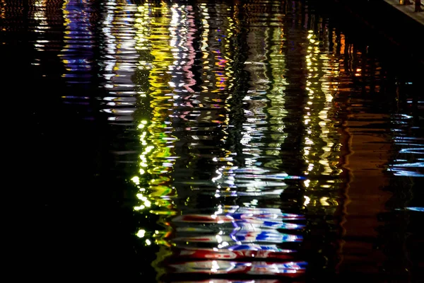 O reflexo das ondas de luz na água Luzes coloridas da cidade r — Fotografia de Stock