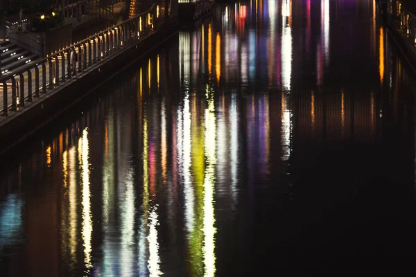 Le reflet des ondes lumineuses dans l'eau Lumières de ville colorées r — Photo