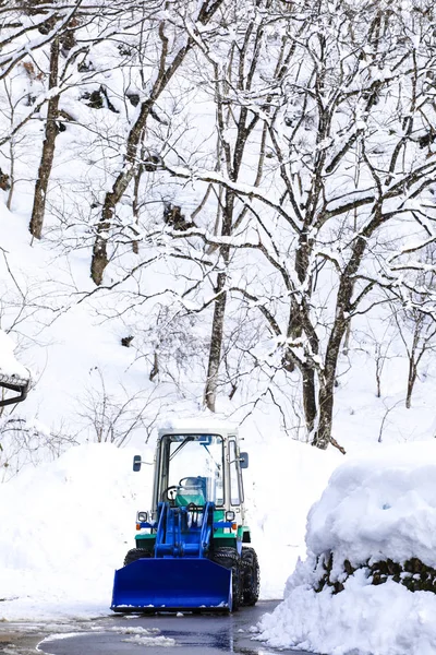 Caricatore neve per rimuovere la neve sulla strada nel villaggio — Foto Stock