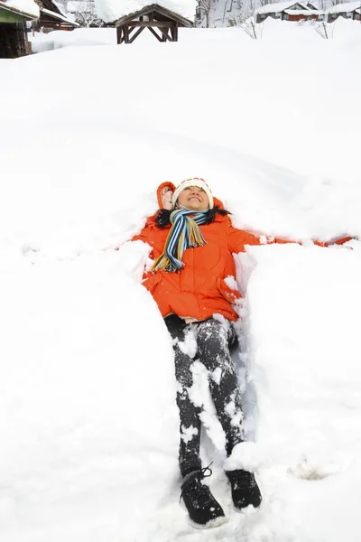 woman lay down on the snow and enjoy snow in the winter
