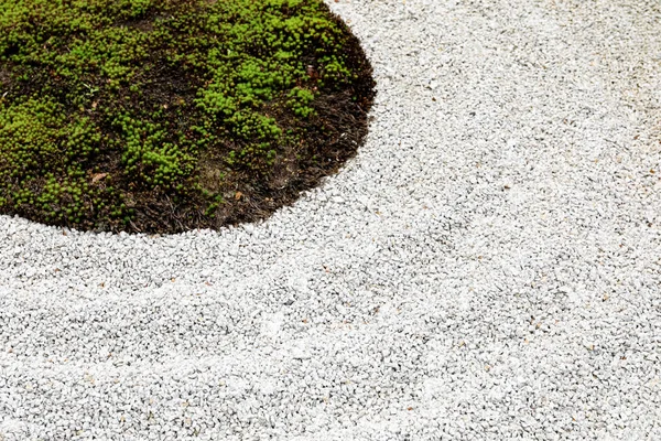 Zahradní podlaha se skládá z malých kamenů a zelené trávy. — Stock fotografie