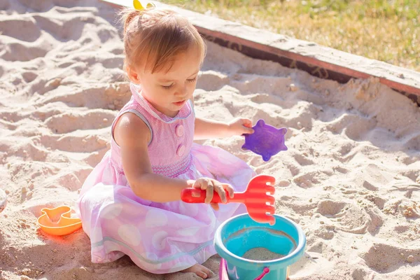 Dziewczynka bawi się piasek w piaskownicy Obrazy Stockowe bez tantiem