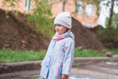 Çamurlu su birikintisi içinde oynayan çocuk