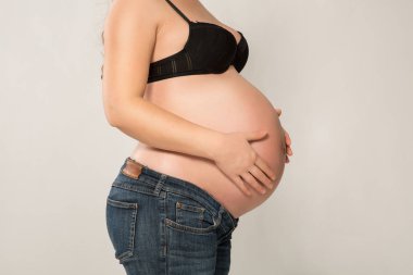 Elleri karnında hamile bir kadın.