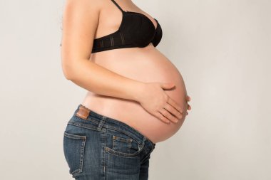 Elleri karnında hamile bir kadın.