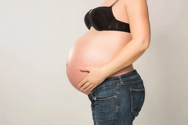 Elleri karnında hamile bir kadın. — Stok fotoğraf