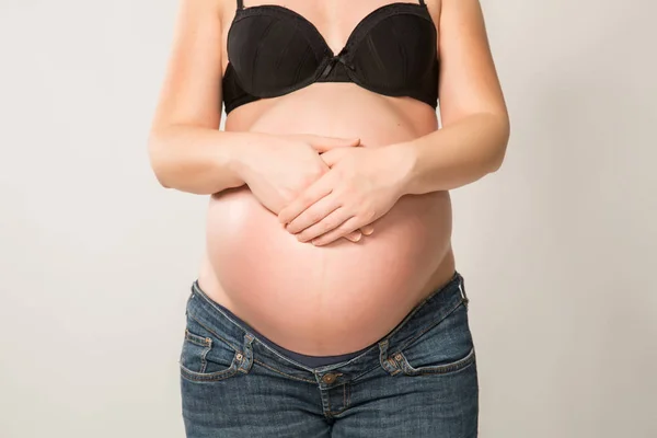 Gravid kvinna med händerna på magen — Stockfoto