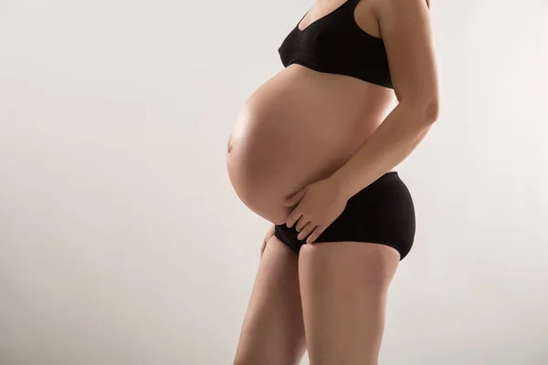 Gravid kvinna i svart underware studio skott — Stockfoto