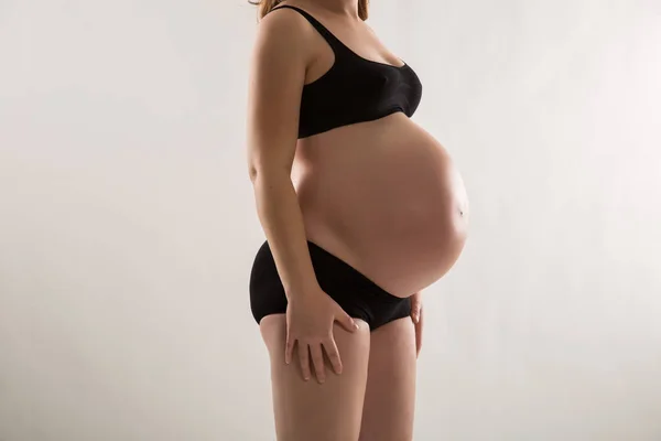 Беременная женщина в черном андерграунде — стоковое фото