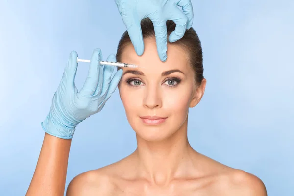 Mulher jovem atraente recebe injeção cosmética de botox. Médicos — Fotografia de Stock