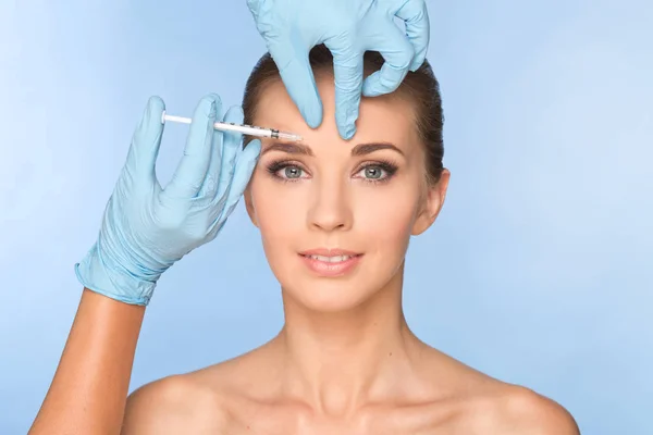 Attractive young woman gets cosmetic injection of botox. Doctors — Stock Photo, Image