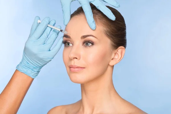 Attractive young woman gets cosmetic injection of botox. Doctors — Stock Photo, Image