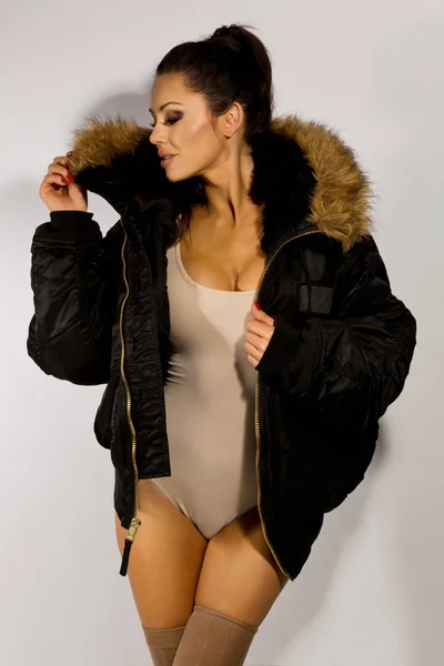 Brunette modèle sexy avec queue de cheval et grande veste posant dans studi — Photo
