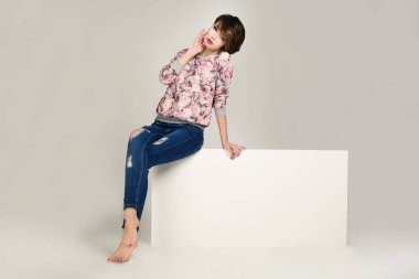 Çekici model Pembe ceket ve kot pantolon giymiş.