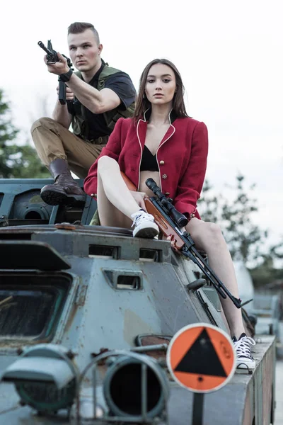 Lövés férfi, egy nő, mellette ül a tartály. — Stock Fotó