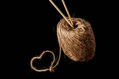 Siyah arka planda iplik ve ahşap örgü iğneleri