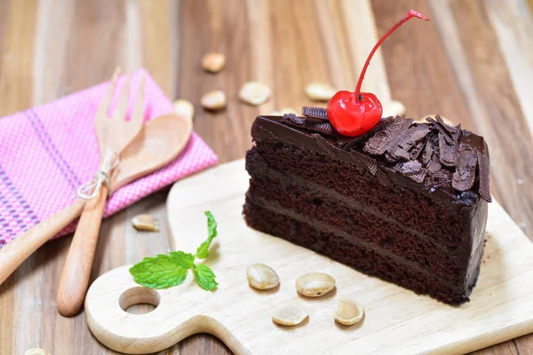 Chocolate cake on wooden plate — Stock Photo, Image