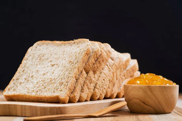 Skiver brød med syltetøy på trebord – stockfoto