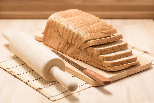 木のテーブルの上でパンをスライス — ストック写真