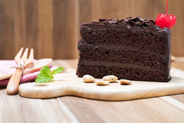 Chocolate cake on wooden plate — Stock Photo, Image