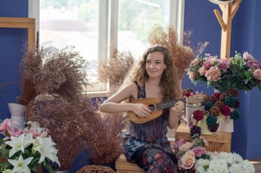 Zevk ve Ukulele mu oynayarak rahatlatıcı gülümseyen kadın