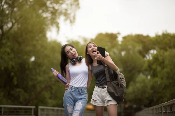 Two young Asia woman friends smiling and walking on street — Stock Photo, Image