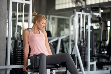 Güçlü kadın ile açılan makine bir fitness kulübünde egzersiz,