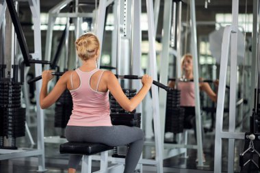 Güçlü kadın ile açılan makine bir fitness kulübünde egzersiz,