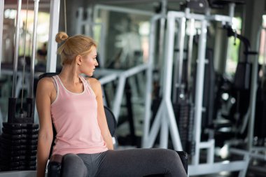 Güçlü kadın ile açılan makine bir fitness kulübünde egzersiz,