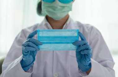 Coronavirus salgını, Genç Asyalı Kadın Doktor Sağlık ve Sağlık Hizmetleri konsepti, tıbbi koruma maskesi gösteriyor.