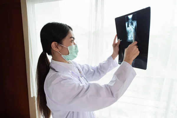 Female radiology doctor examining at x ray film of patient at hospital room, lung radiography, Healthcare and Medical concept