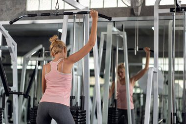 Güçlü genç bir kadın spor salonunda spor yaparken, spor salonunda spor yapıyor.