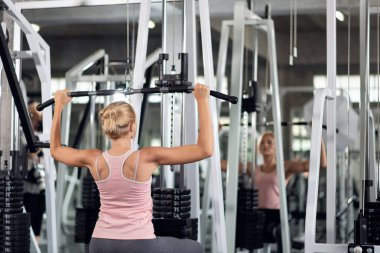 Güçlü genç bir kadın spor salonunda spor yaparken, spor salonunda spor yapıyor.