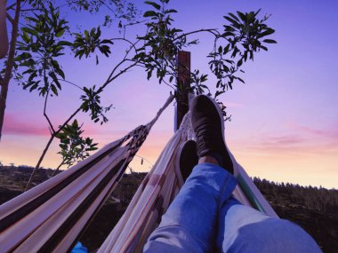 Genç adam hamakta dinleniyor.